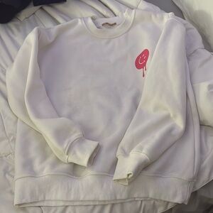 This is a white crewneck with pink smiley faces. It’s very soft and comfy!!